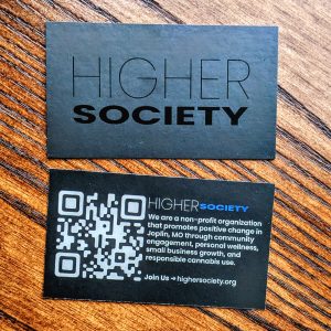 Black shimmer name of business on front with a QR code and information about the organization on back. Both in black. Front is in black lettering and back is in white lettering.