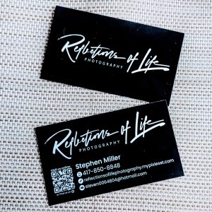 Double sided business card. Black with white lettering. Front has the name of business. Back has the Business name as well as contact information