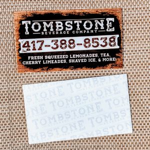 A rough style edge with Tombstone Beverage Company on the front as well as the types of drinks they offer. The back shows the subtle name of the business.