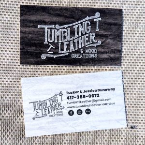 Front is wood back ground with Tumbling T Leather & Wood Designs on front and white and black with contact information on the back